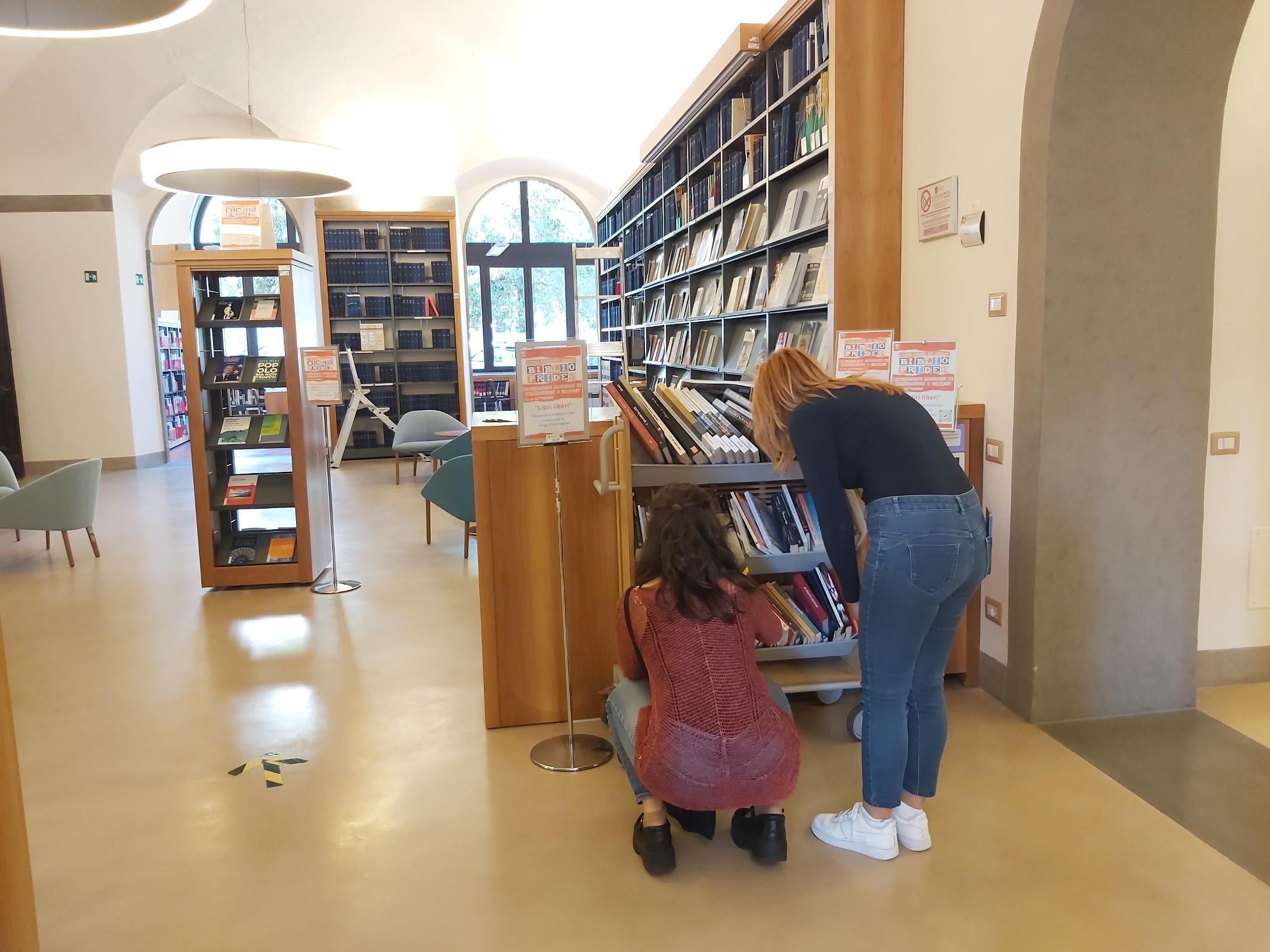 Palazzo Cerretani, alcuni utenti scelgono il libro da portare a casa dallo scaffale "Libri liberi"