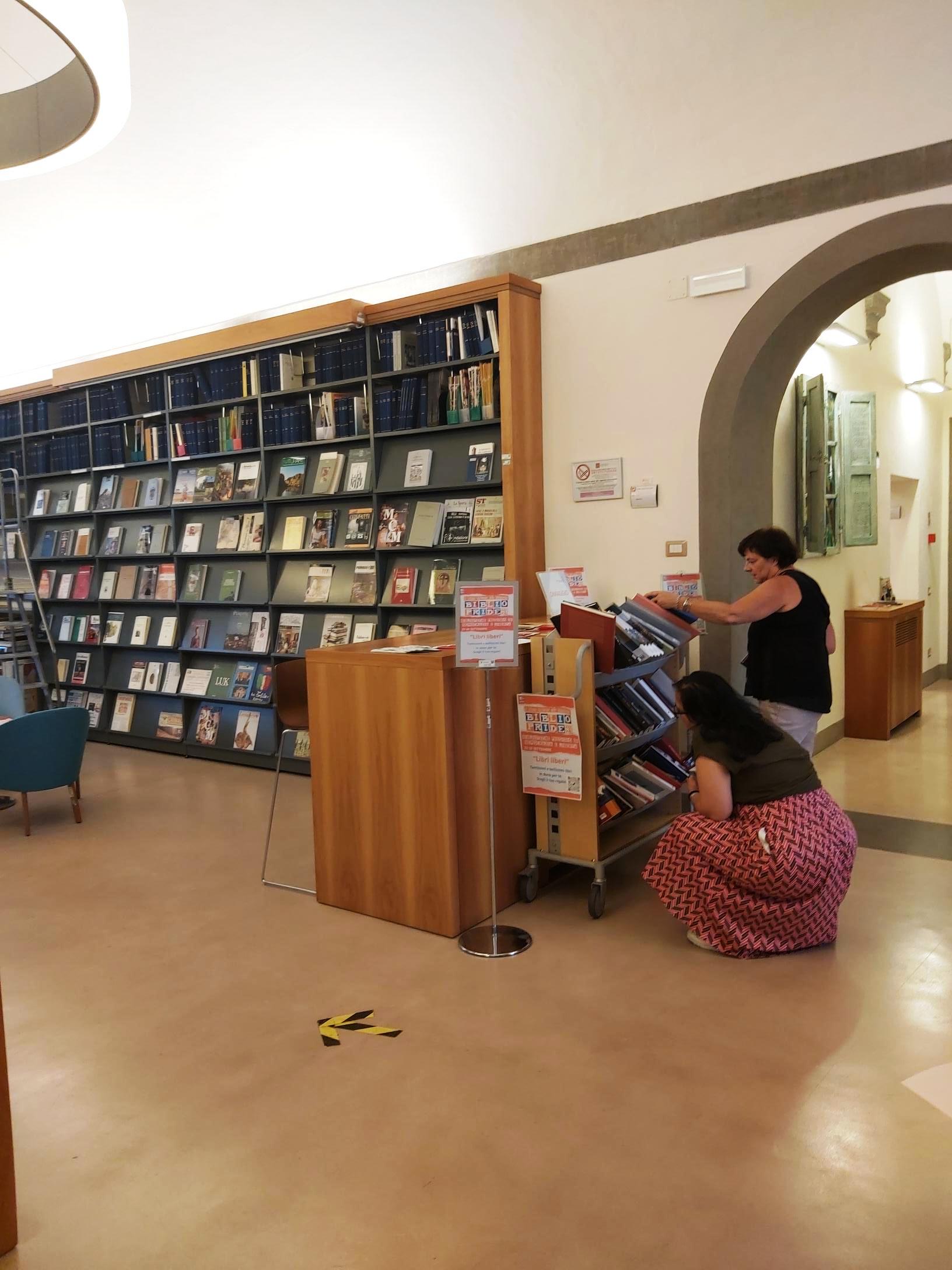 Palazzo Cerretani, alcuni utenti scelgono il libro da portare a casa dallo scaffale "Libri liberi"	