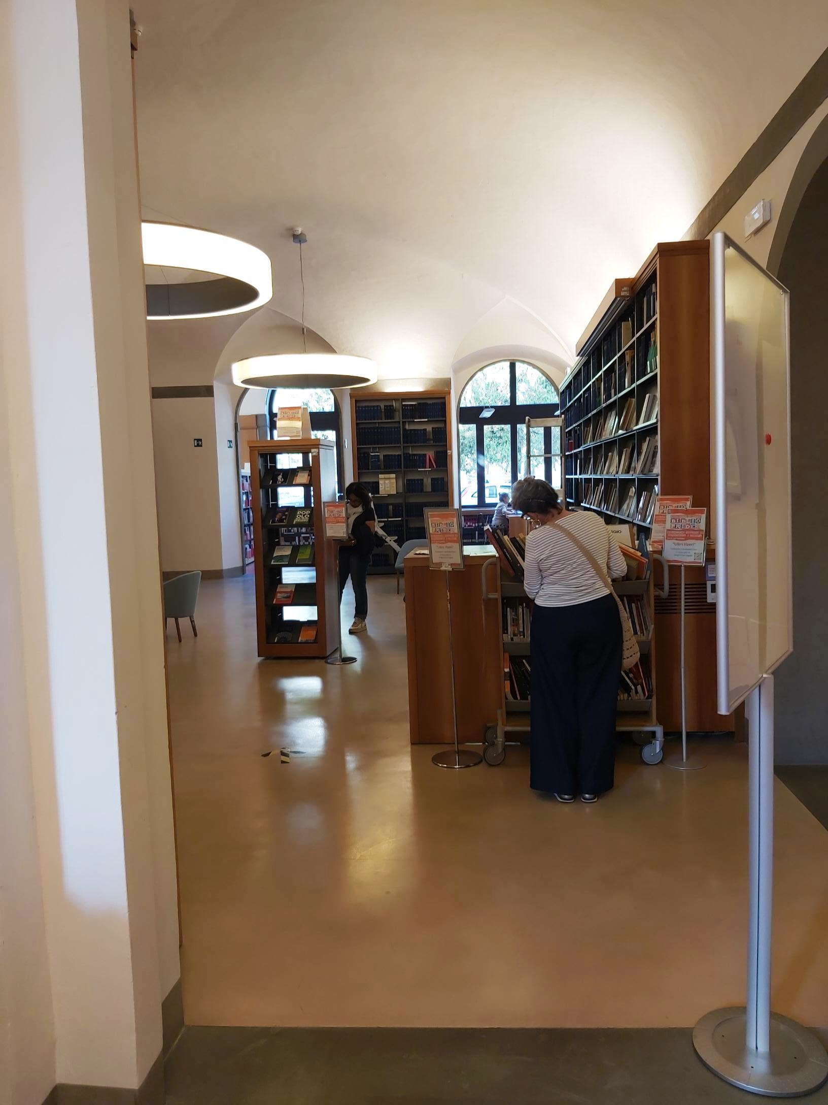 Palazzo Cerretani, alcuni utenti scelgono il libro da portare a casa dallo scaffale "Libri liberi"	